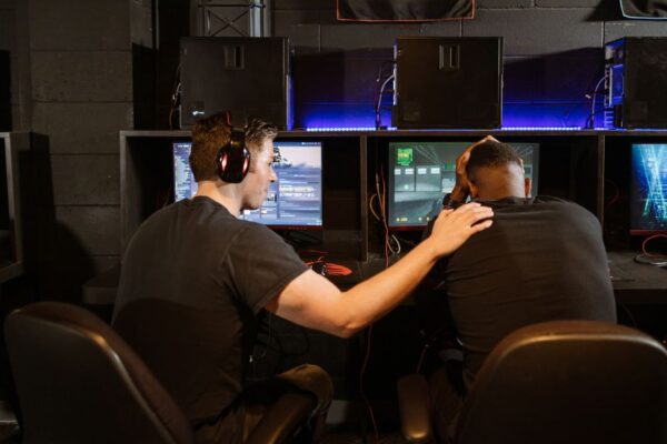 A person looking frustrated at their computer screen which shows a high ping notification during a game.