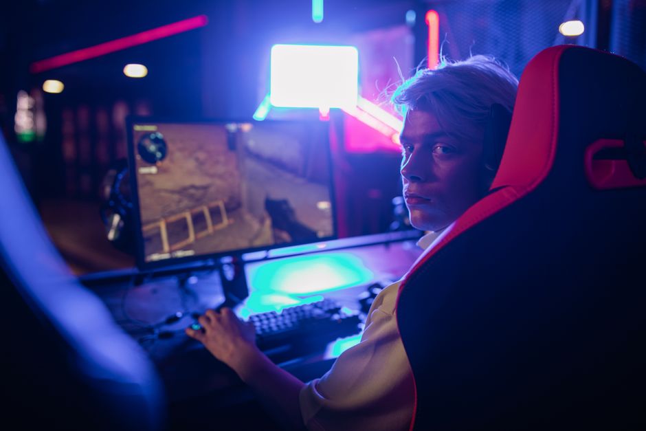 A person's hands on a keyboard, looking at a computer screen displaying a prominent 'SCAM WARNING' notification over a game interface.