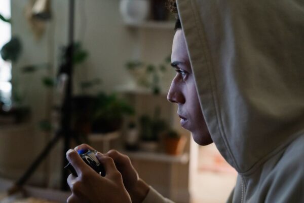 A person sitting in front of a computer screen displaying hundreds of unplayed game icons in a Steam library, looking overwhelmed.