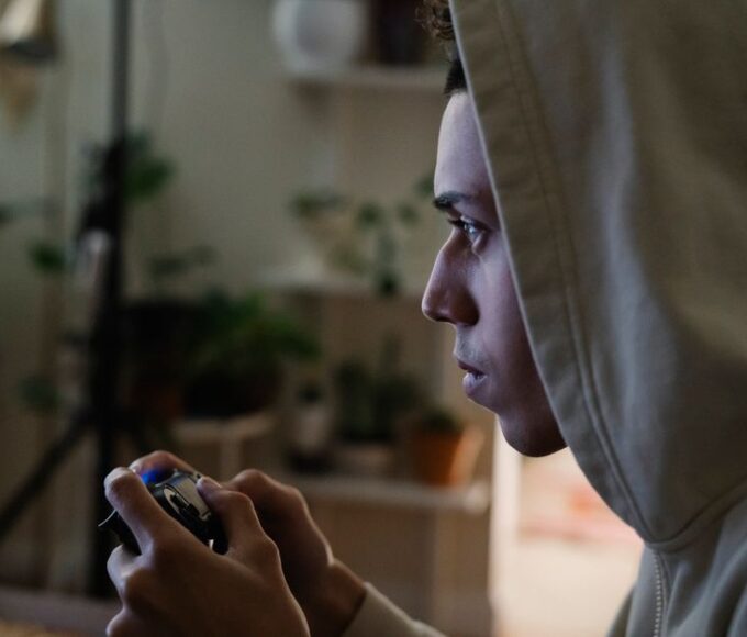 A person sitting in front of a computer screen displaying hundreds of unplayed game icons in a Steam library, looking overwhelmed.