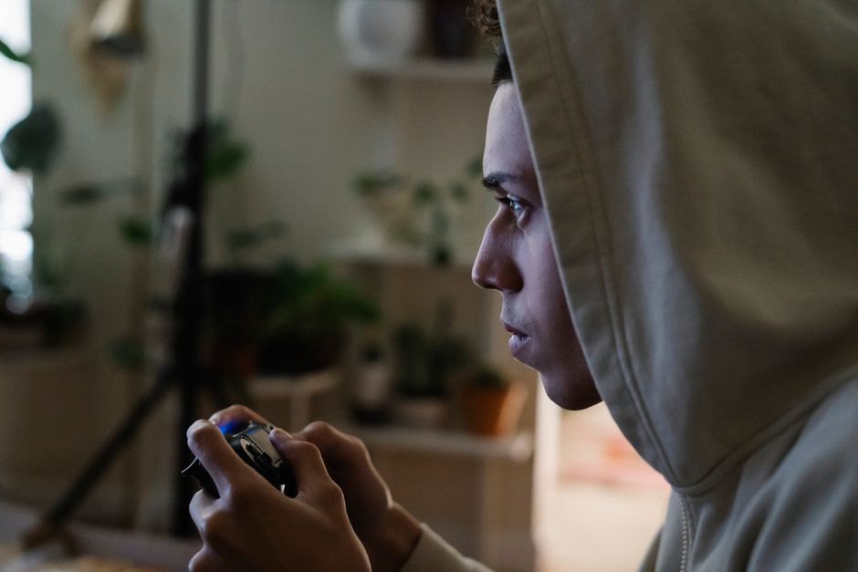 A person sitting in front of a computer screen displaying hundreds of unplayed game icons in a Steam library, looking overwhelmed.