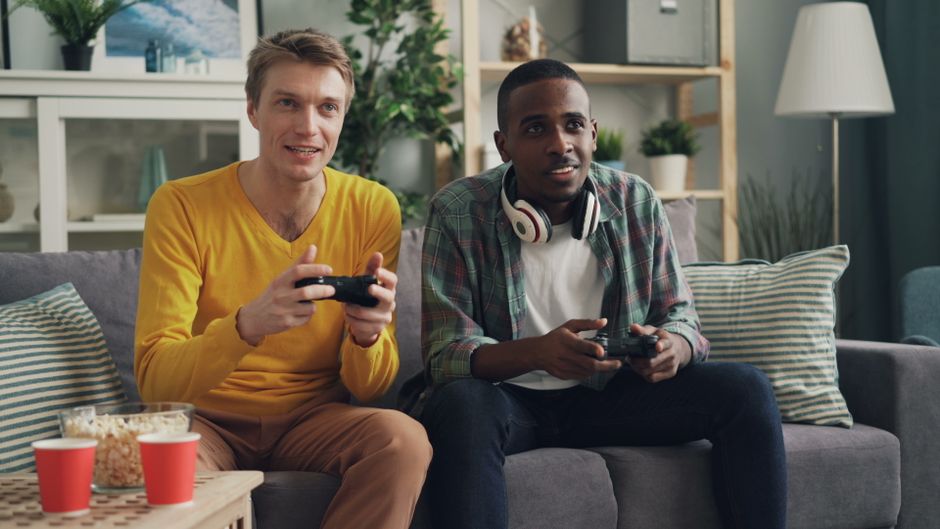 A PlayStation 5, Xbox Series X, and Nintendo Switch console displayed side by side on a shelf, highlighting their different designs.