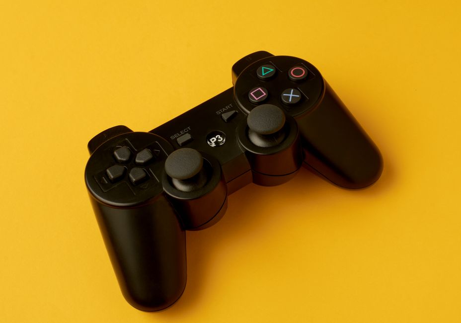 A close-up of a gaming controller with a glowing two-factor authentication (2FA) symbol overlaid, emphasizing digital protection for gamers.