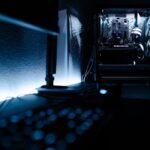 Close-up of a gaming PC setup with a monitor displaying a game, keyboard, and mouse.