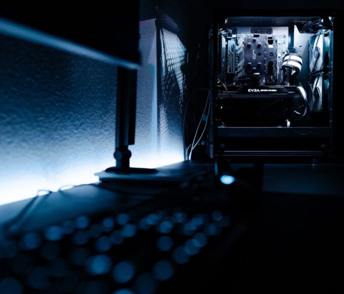 Close-up of a gaming PC setup with a monitor displaying a game, keyboard, and mouse.