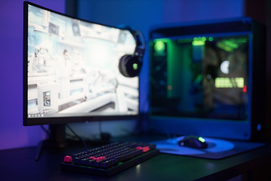 A clean and ergonomic PC gaming setup with a low-sensitivity mouse, large mousepad, and comfortable chair, illustrating optimal player posture.