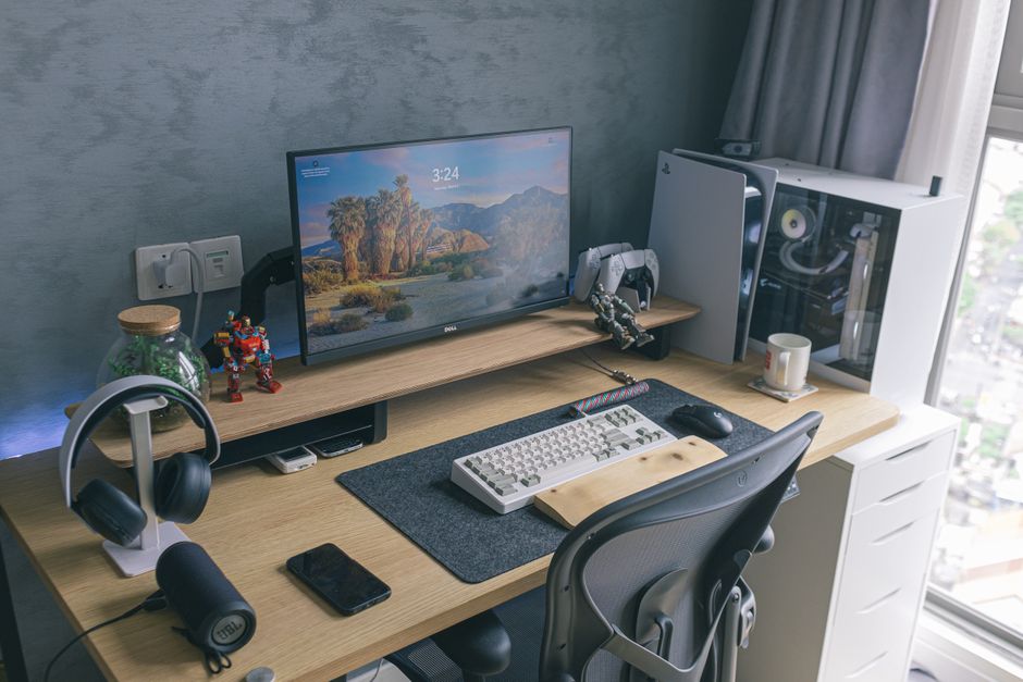 A clean, ergonomic gaming setup featuring an adjustable chair, monitor at eye level, and an organized desk with a plant.