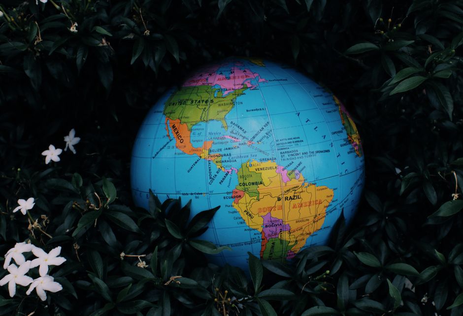 An abstract digital globe with glowing lines connecting various continents (Europe, North America, South America), symbolizing the global reach and impact of AI and its regulatory frameworks.