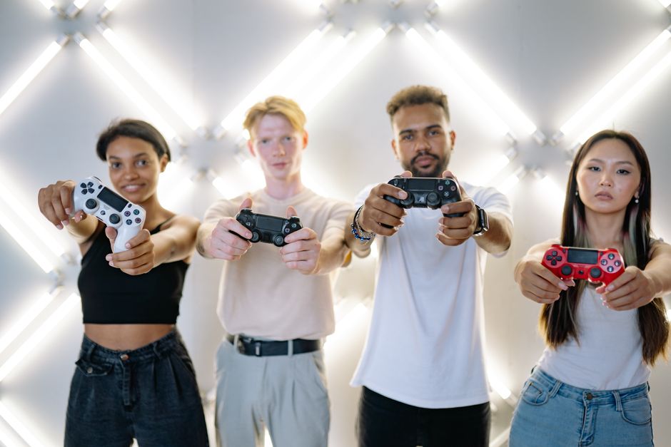 A diverse group of friends, some on consoles, others on PC, laughing and interacting while playing crossplay games.