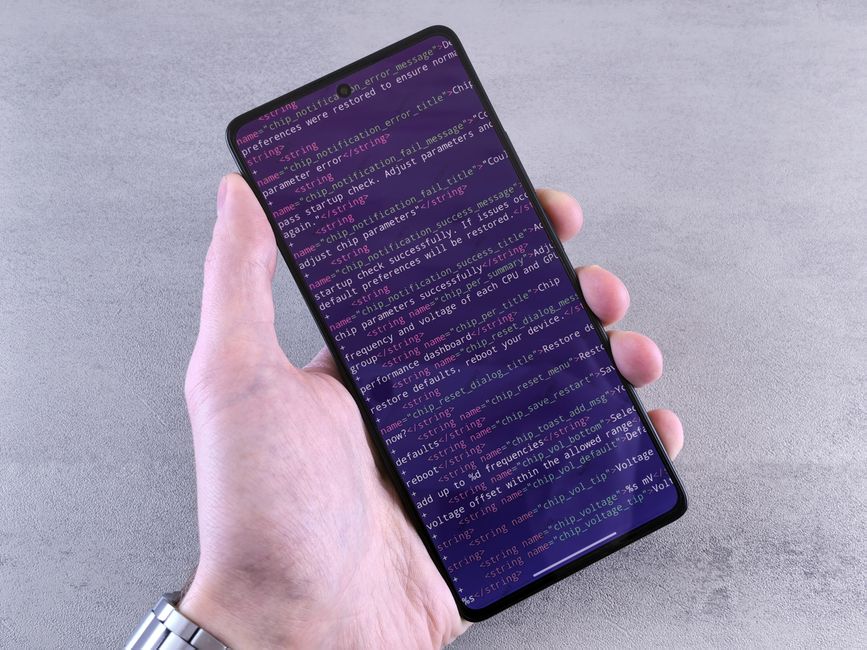 A hand holding a smartphone displaying a six-digit two-factor authentication code, symbolizing secure login.