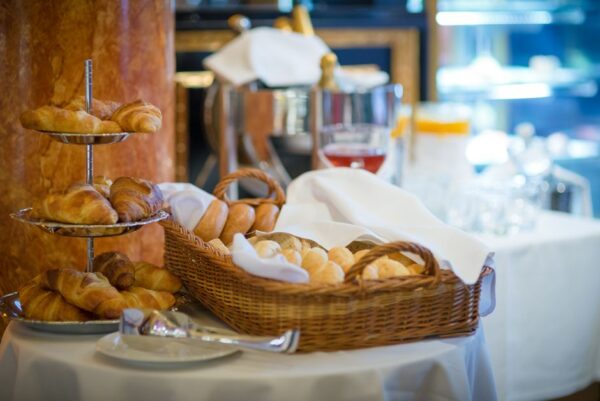 A typical hotel continental breakfast featuring several types of pastries, coffee, and a limited selection of fruit, highlighting the common challenge for healthy travel breakfasts.