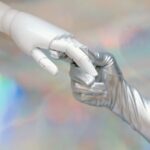 A human hand gently holding a smaller robot hand, symbolizing the partnership and necessary human control over AI.