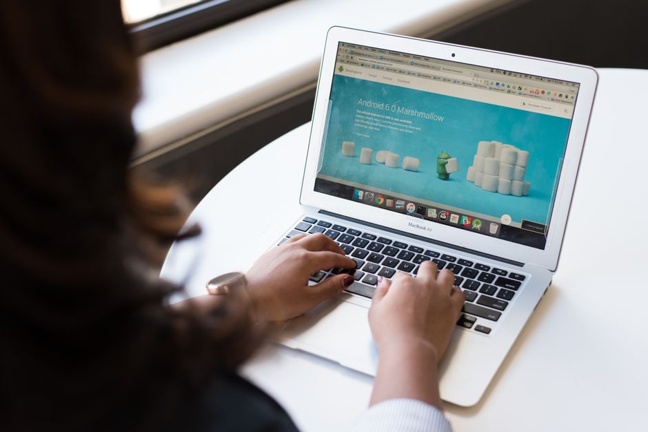 A person's hand interacting with a laptop, showing a web browser with various extension icons and an AI-powered pop-up, symbolizing productivity tools.