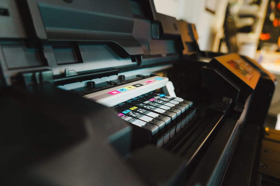 A side-by-side comparison illustrating a laser printer next to an inkjet printer on a desk, highlighting their physical differences.