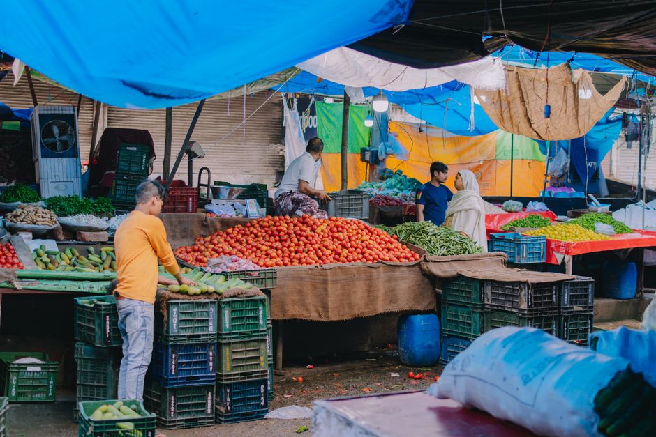An abundant stall at a farmer's market filled with fresh, seasonal fruits and vegetables, displaying local produce.