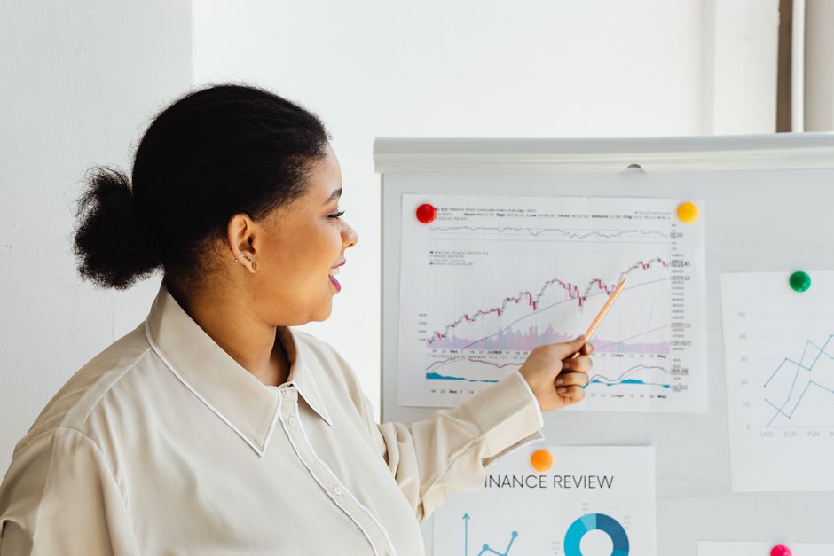 A diverse group of marketing professionals in a modern office collaborating on AI-generated images for a global campaign, with a focus on a screen showing refined visuals.