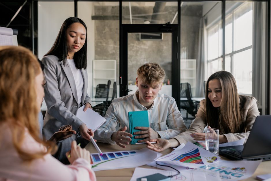 A diverse marketing team in a modern office, gathered around a large screen displaying AI-generated content, actively discussing and refining it.