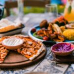 A vibrant Mediterranean lunch spread with olive oil, fresh vegetables, whole-grain bread, and olives.