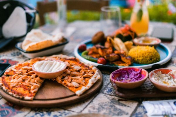 A vibrant Mediterranean lunch spread with olive oil, fresh vegetables, whole-grain bread, and olives.