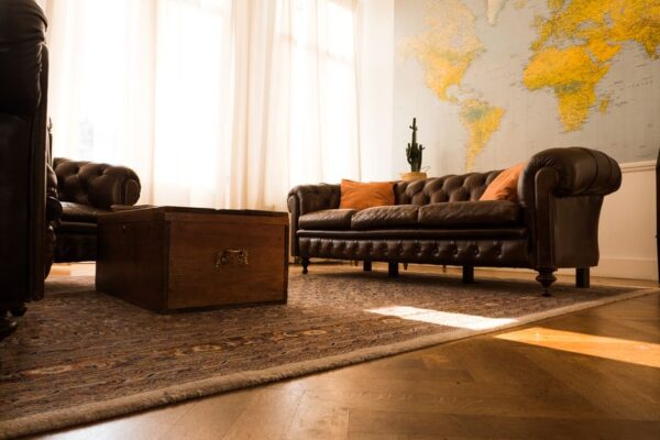 A clean, modern living room with a neutral palette, featuring a few strategically placed unique artisan pieces from around the world, like a carved wooden statue and a colorful woven throw blanket.