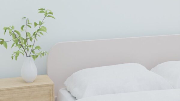 A bright, minimalist bedroom with neutral tones, clean lines, and a large window, suggesting calm and spaciousness.