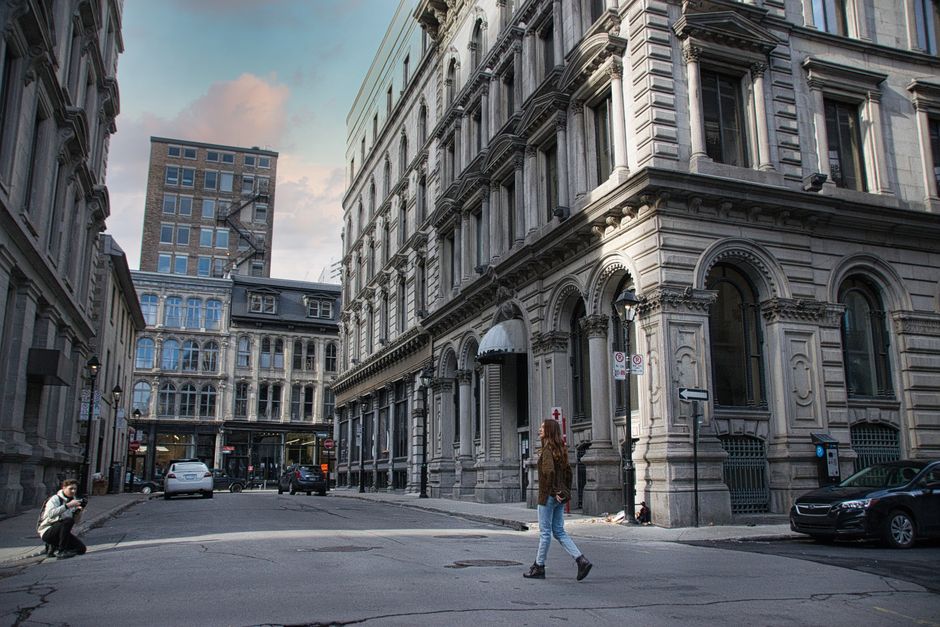 A charming, car-free cobblestone street in Old Montreal, lined with historic buildings and people strolling, showcasing walkability.
