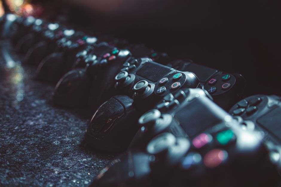 A collection of handheld gaming devices, including a Nintendo Switch OLED, a Steam Deck, and an ASUS ROG Ally, laid out on a table.