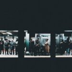 A bustling New York City subway platform with a train arriving, commuters waiting, illustrating efficient public transit.