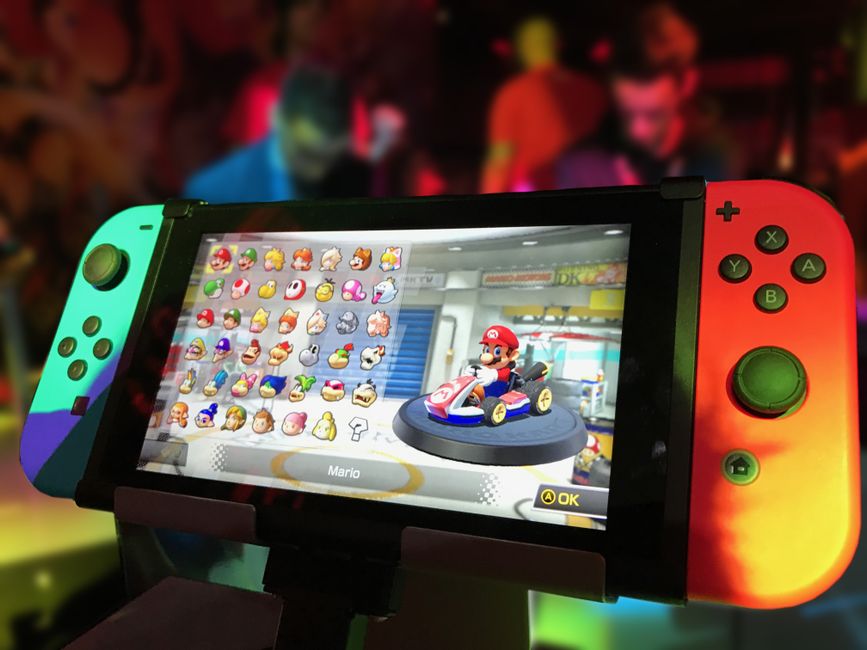A child in the backseat of a car holding a Nintendo Switch, immersed in an exploration game during a long family road trip.