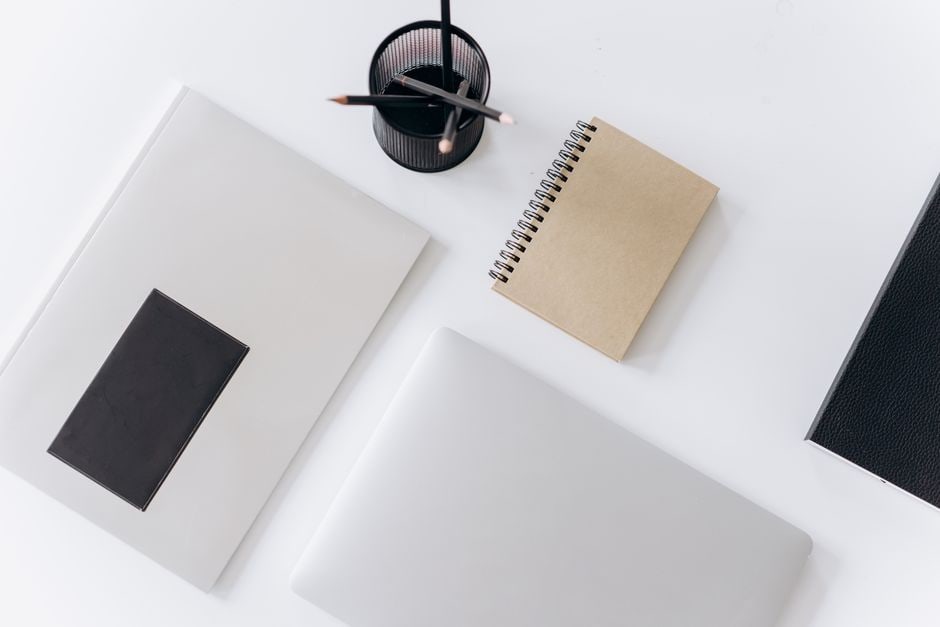 A clean, minimalist desk setup with a laptop, a single plant, and no clutter, representing a simplified work environment.