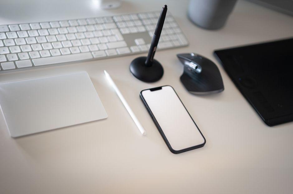 An organized desk featuring only a laptop, a smartphone, and a smart display, demonstrating a streamlined and functional minimal tech setup.