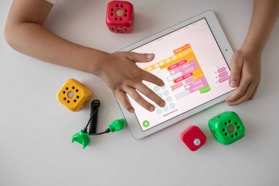 Overhead shot of a child's hands meticulously arranging toy blocks to construct a detailed city model, emphasizing planning.