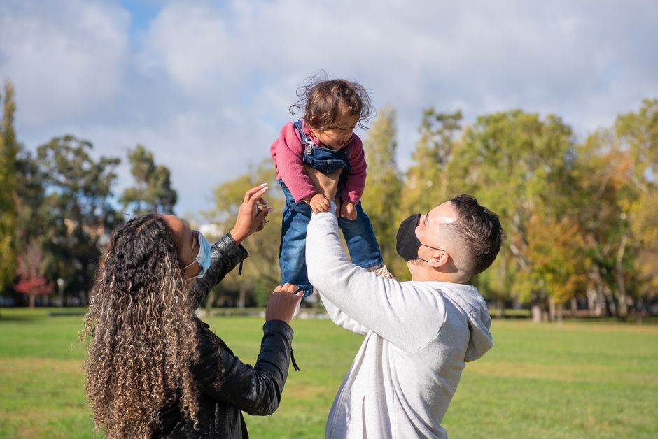 A parent and child wearing protective masks while walking through a clean, modern urban park, emphasizing allergy prevention in a city setting.