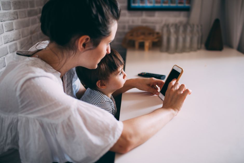 A family navigating a bustling European city street, with one parent subtly checking an allergy app on their phone, indicating active management of seasonal allergies while traveling.