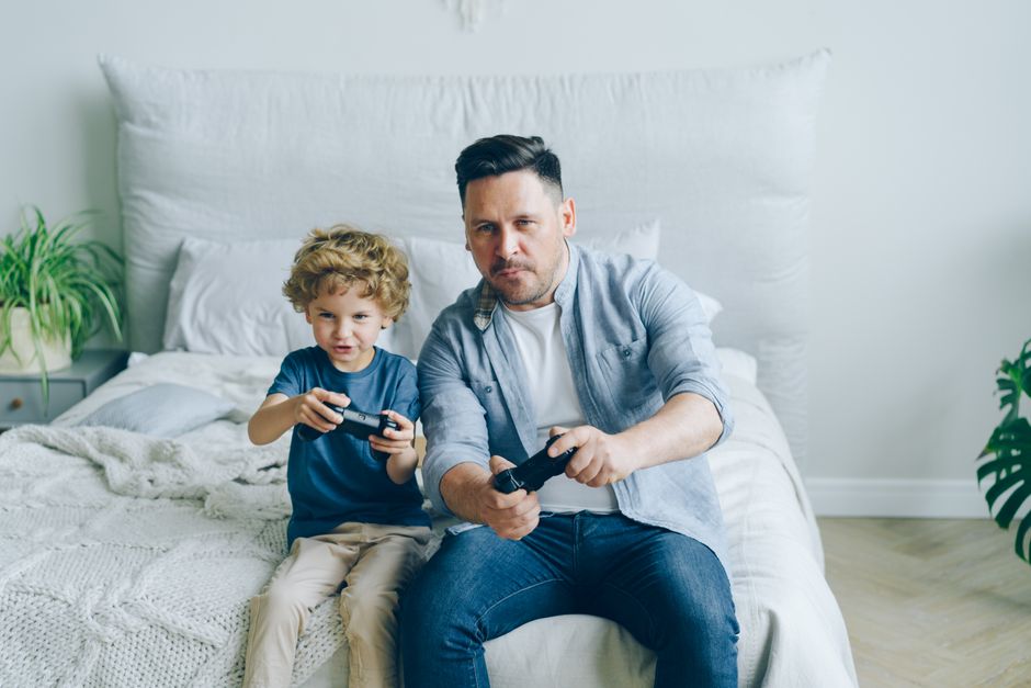 Parents sitting on a couch, talking to their child about screen time rules, with a tablet visible but off.