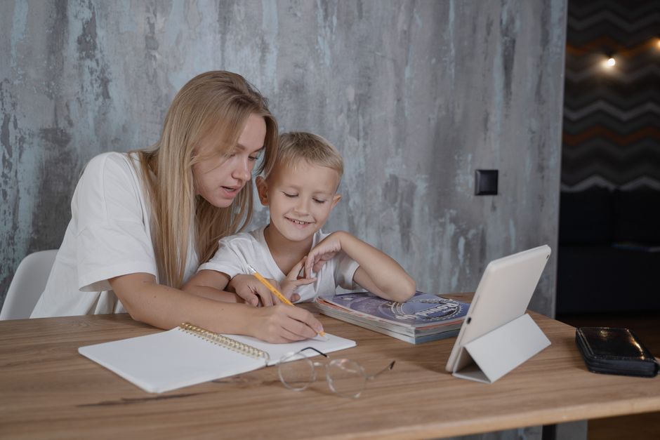 A parent and child happily looking at a tablet together, demonstrating guided and safe screen time usage within established family tech rules.