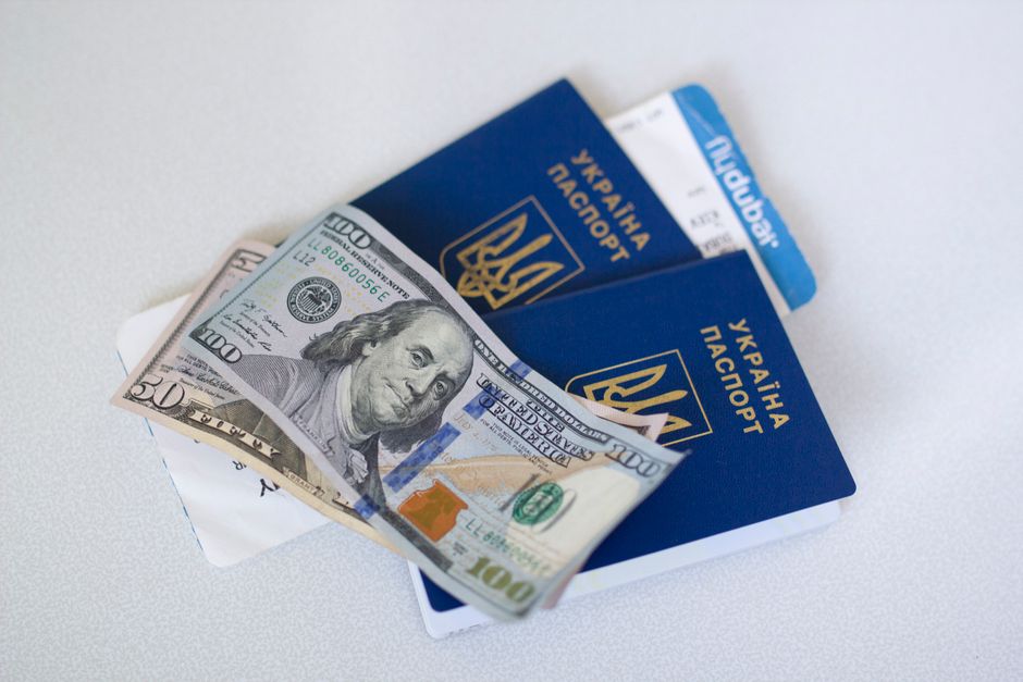 A small, well-organized travel first aid kit next to a passport and a variety of international currencies.