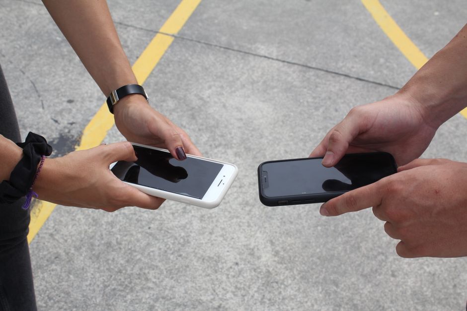 Three phones side-by-side displaying iCloud, Google Photos, and OneDrive apps, representing choice in cloud storage.