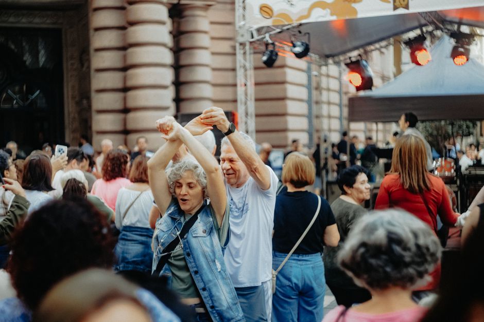 A group of friends enjoying a music festival, dressed in breathable fabrics and hands-free bags, illustrating practical festival outfits in action.