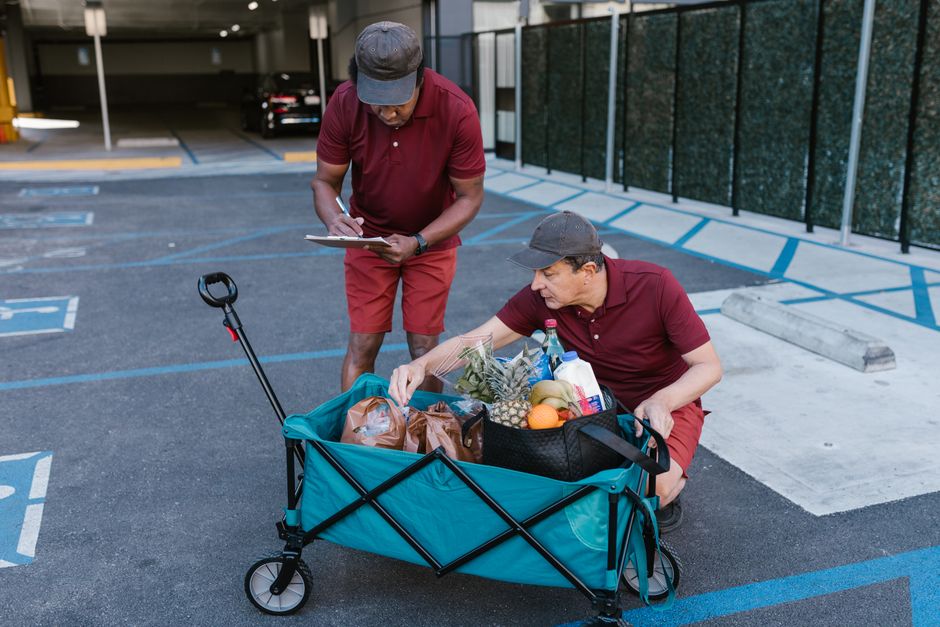 Diverse individuals walking through a vibrant urban neighborhood, carrying grocery bags and engaging in daily errands, demonstrating active local living.