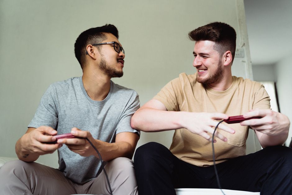 A group of diverse friends gathered on a sofa, deeply engrossed in a shared-screen video game, celebrating a score.