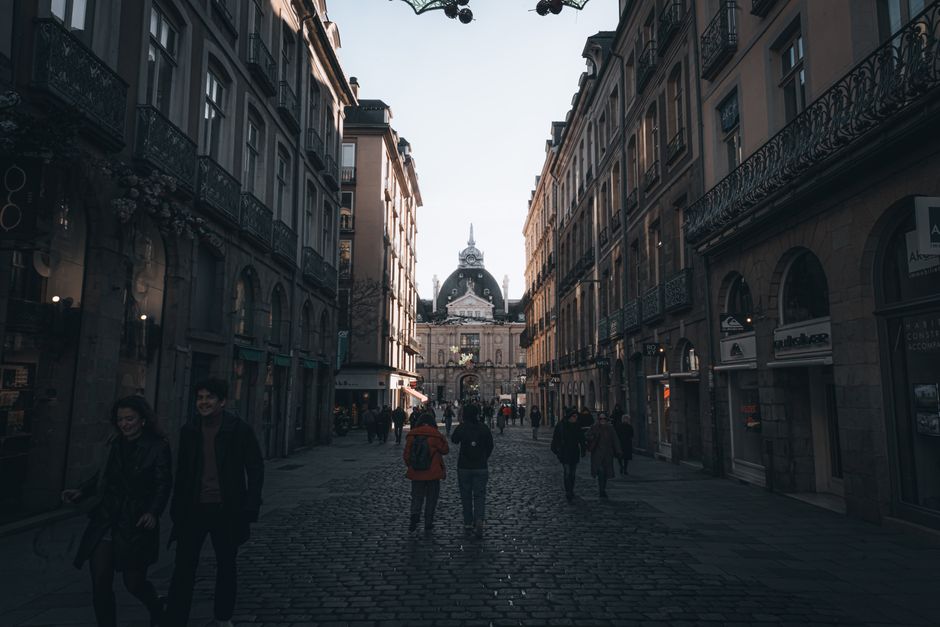 People leisurely walking down a vibrant street in Barcelona, Spain, enjoying the scenery and incorporating movement into their day.