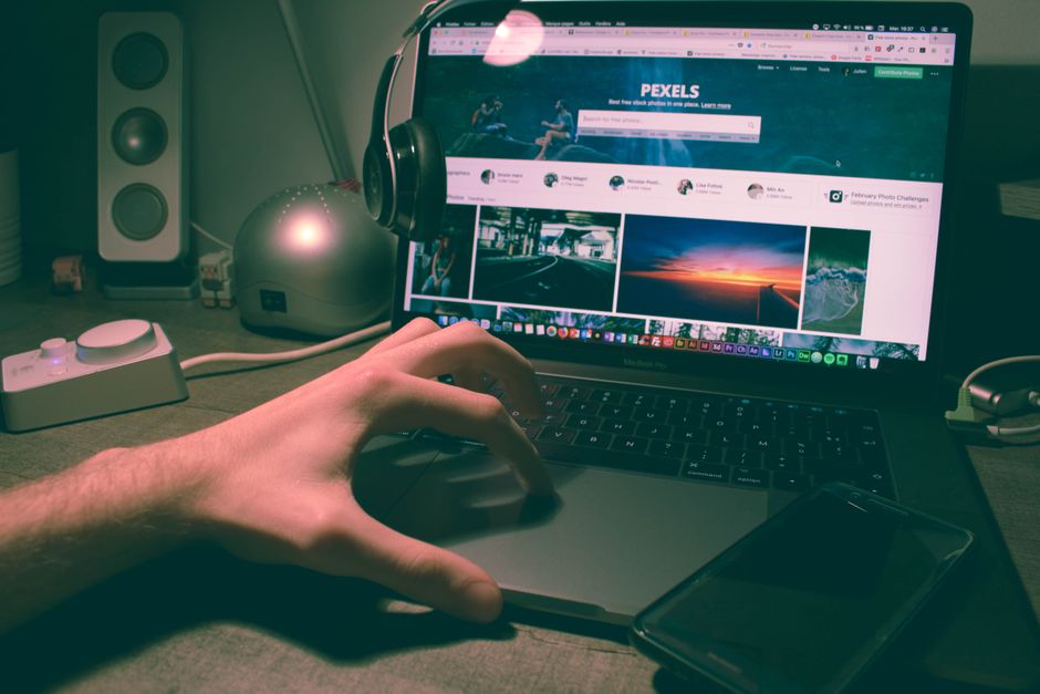 A person sitting at a desk, looking at a laptop screen displaying multiple tabs of different game review websites, symbolizing research.