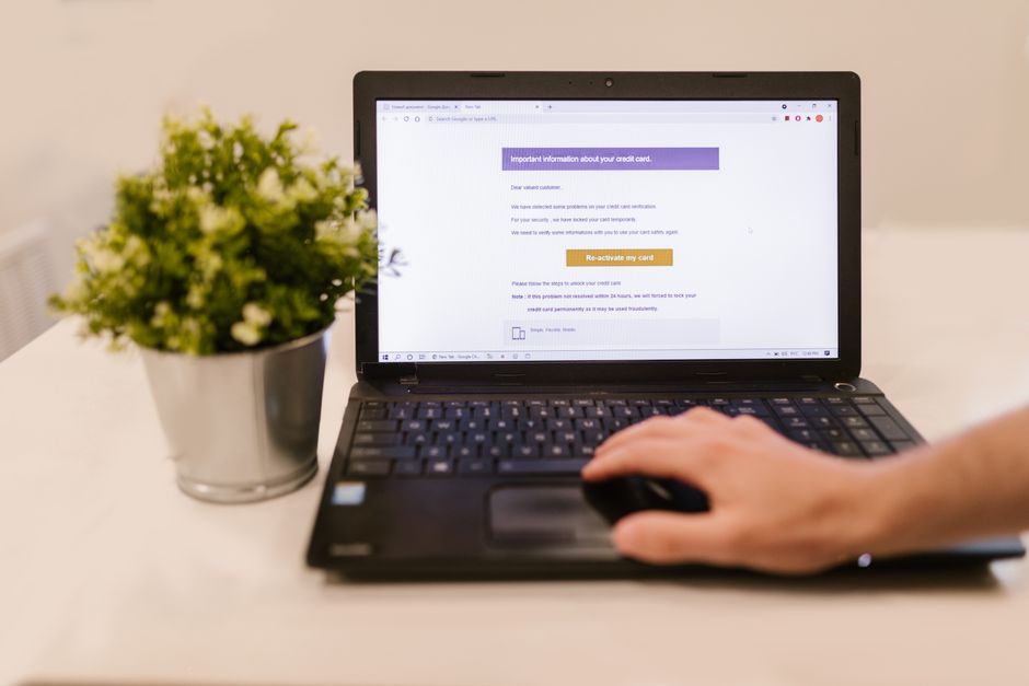 A close-up shot of hands on a laptop keyboard, with a mouse pointer hovering over an 'Archive' button in an email client, symbolizing the act of decluttering the inbox.