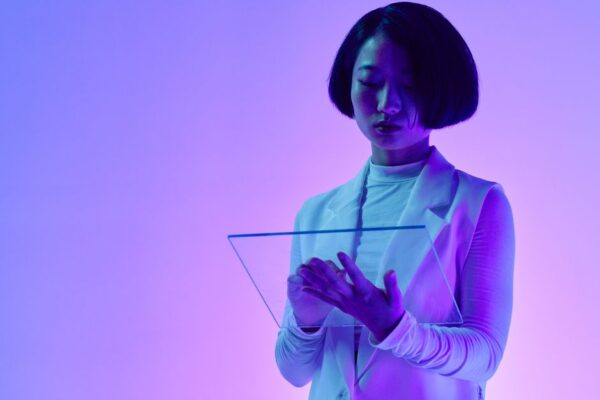 A person interacting with an AI interface projected as a hologram, symbolizing collaboration between humans and AI in a modern workplace.