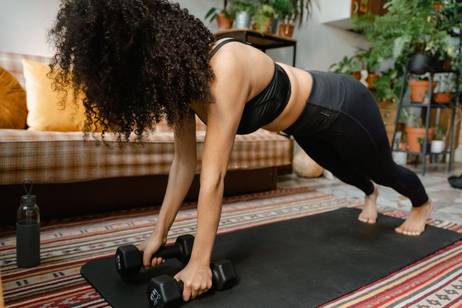 A person performing a plank variation on an exercise mat in a small apartment living room, showcasing effective bodyweight training in limited space.