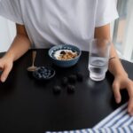A person enjoying a bowl of Greek yogurt topped with fresh berries, representing an easy, high-protein breakfast.