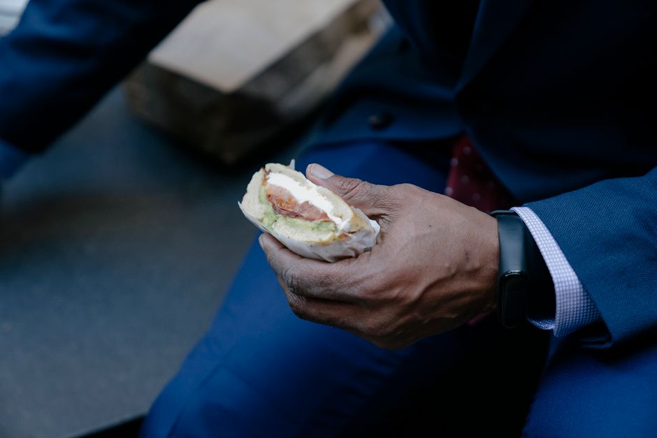 A remote worker on a clean, well-lit train car enjoys a healthy snack of an apple and almonds, looking out the window, illustrating mindful eating and healthy habits public transit commute.
