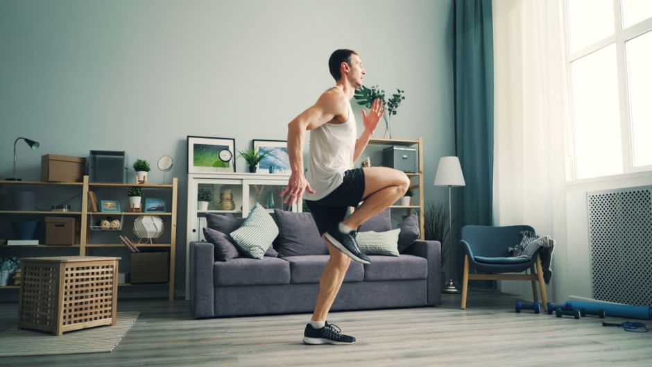 A person performing a yoga pose in a bright living room, symbolizing indoor winter fitness.