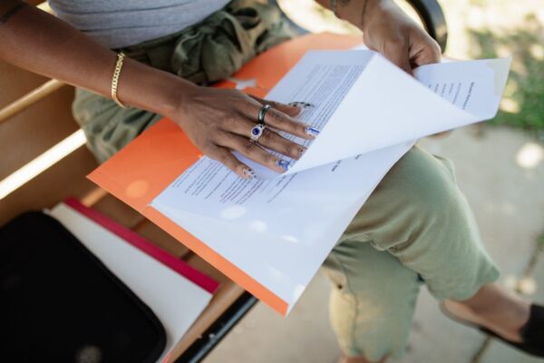A person with glasses meticulously reviewing printed documents and digital text, symbolizing human editorial oversight.